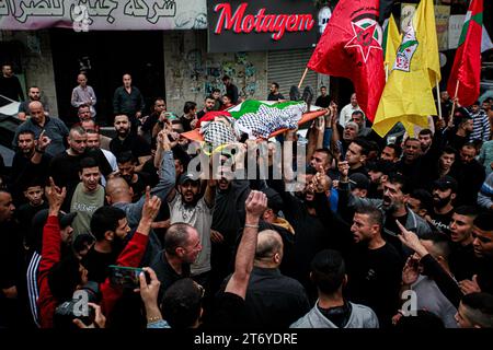 Djénine, Palestine. 12 novembre 2023. (NOTE DE LA RÉDACTION : l'image représente la mort)les personnes en deuil portent le corps d'Amer Arqawi lors de ses funérailles, un jour après qu'il ait été tué lors d'un raid israélien dans la ville de Djénine en Cisjordanie. Selon le Ministère palestinien de la santé, un palestinien a été tué et trois autres ont été blessés lors d ' affrontements avec les troupes israéliennes. Depuis le 07 octobre 2023, 185 Palestiniens ont été tués et plus de 2 000 blessés en Cisjordanie. Crédit : SOPA Images Limited/Alamy Live News Banque D'Images