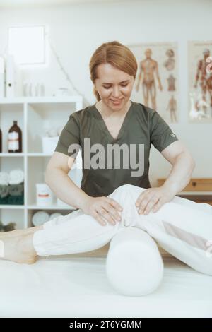 Le temps des soins de santé. femme thérapeute de massage souriant dans l'armoire de massage avec le client effectuant l'examen. Banque D'Images