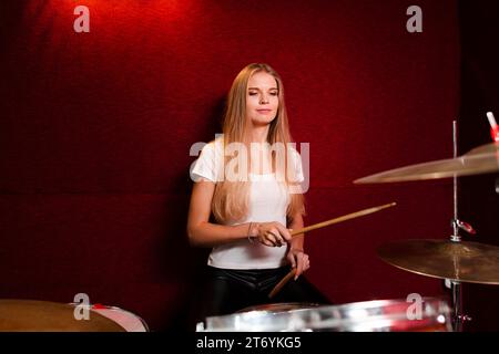 Vue de face latérale fille jouant de la batterie Banque D'Images