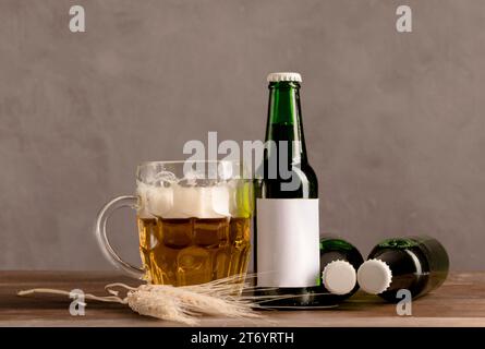 Bière en verre avec bouteilles vertes mousse bière table en bois Banque D'Images