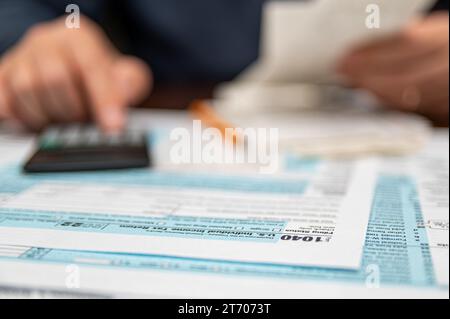 Un homme qui organise la déclaration de revenus individuelle 1040 et les reçus. Arrière-plan flou. Temps fiscal.concept fiscal. Gros plan. Banque D'Images