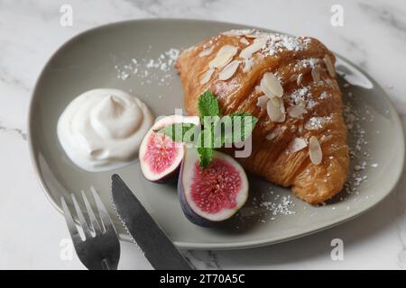 Délicieux croissant avec figue servi sur une table en marbre blanc, gros plan Banque D'Images