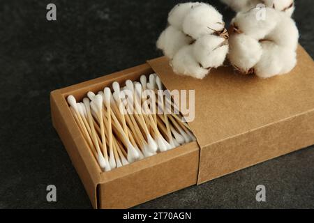 Cotons-tiges et fleurs sur table noire, gros plan Banque D'Images