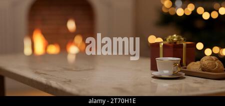 Image rapprochée d'une table en marbre de luxe avec une tasse à café, une boîte cadeau et un panier à pain dans un beau salon confortable avec une cheminée la nuit. 3 Banque D'Images