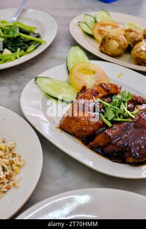 Un repas de riz frit au crabe, boulettes de chair de crabe, côtes de porc BBQ collantes et feuilles de patate douce sautées à l'ail dans un restaurant Hokkien im Kuala Lumpur Banque D'Images