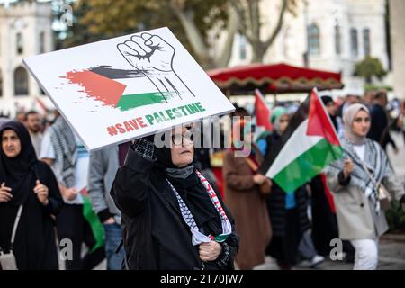 Istanbul, Turquie. 12 novembre 2023. Un manifestant a été vu portant un drapeau palestinien disant "sauver la Palestine" et une bannière représentant un poing. Palestine Initiative Platform a formé une chaîne humaine d'Edirnekapi à Sultanahmet pour protester contre les attaques israéliennes sur Gaza. Crédit : SOPA Images Limited/Alamy Live News Banque D'Images