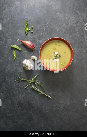 Soupe de pois fendue au-dessus de la vue sur fond noir avec des ingrédients autour Banque D'Images