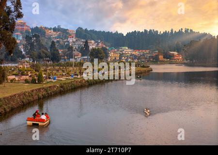 Lac Mirik avec son paysage urbain et vue des touristes en bateau au coucher du soleil. Mirik est une station de montagne populaire dans le district de Darjeeling au Bengale occidental, en Inde. Banque D'Images