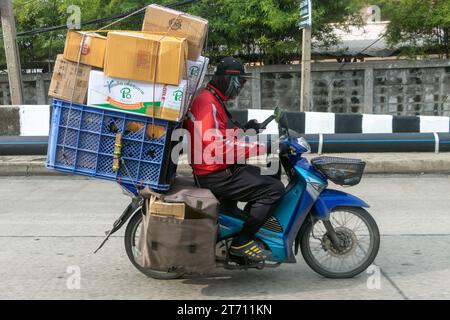 SAMUT PRAKAN, THAÏLANDE, NOVEMBRE 09 2023, livraison de colis en moto dans les rues de la ville Banque D'Images