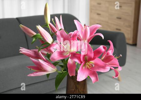 Belles fleurs de lys roses dans un vase à la maison, gros plan Banque D'Images