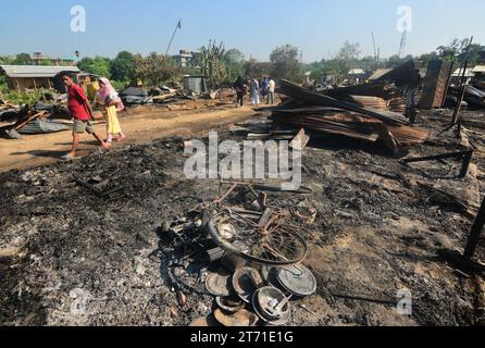 Dimapur, Inde : 13 novembre 2023 : les résidents marchent devant leur maison carbonisée après un enfer dans la nuit de Diwali, la fête hindoue de la lumière, qui a détruit au moins 50 maisons tuant 5 personnes à Naharbari à Dimapur, en Inde, dans l'état nord-est du Nagaland. Crédit : Caisii Mao/Alamy Live News Banque D'Images