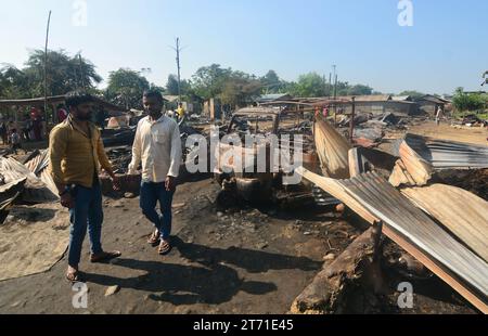 Dimapur, Inde : 13 novembre 2023 : les résidents marchent devant leur maison carbonisée après un enfer dans la nuit de Diwali, la fête hindoue de la lumière, qui a détruit au moins 50 maisons tuant 5 personnes à Naharbari à Dimapur, en Inde, dans l'état nord-est du Nagaland. Crédit : Caisii Mao/Alamy Live News Banque D'Images