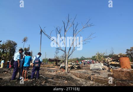 Dimapur, Inde : 13 novembre 2023 : un étudiant regarde entre la maison carbonisée après un enfer dans la nuit de Diwali, la fête hindoue de la lumière, qui a détruit au moins 50 maisons tuant 5 personnes à Naharbari à Dimapur, en Inde, dans l'état nord-est du Nagaland. Crédit : Caisii Mao/Alamy Live News Banque D'Images