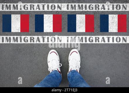 Immigration. Homme debout sur l'asphalte près du drapeau de la France, vue de dessus Banque D'Images