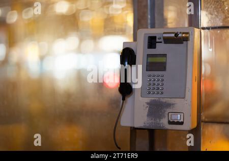 Téléphone accroché dans la rue de la ville de nuit Banque D'Images