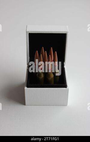 Photo concept de Bullets dans la boîte à bijoux blanche sur fond blanc Banque D'Images