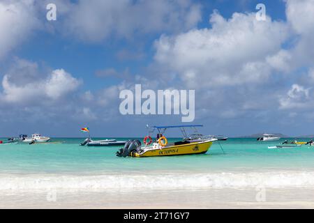 Praslin, Seychelles - 14 août 2023 : bateaux à moteur de plaisance ancrés devant la plage de la Côte Dor un jour d'été Banque D'Images