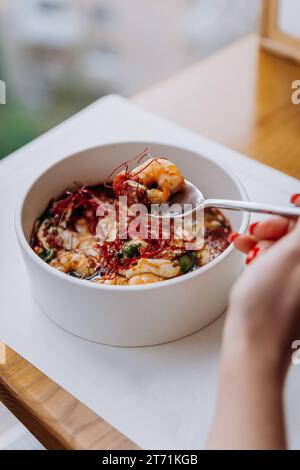 Gros plan de femme mangeant de la nourriture thaïlandaise de porridge de citrouille avec des crevettes dans le restaurant Banque D'Images