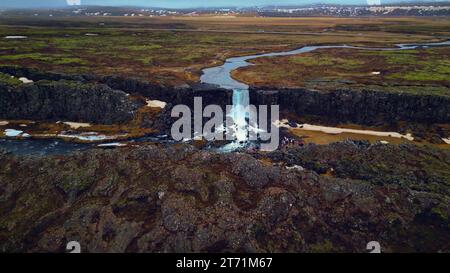 Vue aérienne de la cascade d'oxarafoss en islande, spectaculaire énorme cascade d'eau tombant des falaises. Paysage islandais avec rivière coulant des montagnes. Ralenti. Banque D'Images