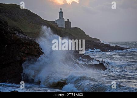 Swansea, Royaume-Uni. 13 novembre 2023. Les vagues s'écrasent dans les rochers du phare de Mumbles et du promontoire près de Swansea peu après le lever du soleil alors que Storm Debi se déplace dans le sud du Royaume-Uni ce matin. Crédit : Phil Rees/Alamy Live News Banque D'Images