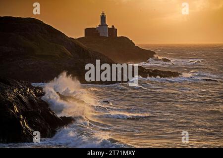 Swansea, Royaume-Uni. 13 novembre 2023. Les vagues s'écrasent dans les rochers du phare de Mumbles et du promontoire près de Swansea peu après le lever du soleil alors que Storm Debi se déplace dans le sud du Royaume-Uni ce matin. Crédit : Phil Rees/Alamy Live News Banque D'Images