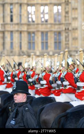 Officier de police avec des membres de la Household Cavalry attendant à Westminster lors de la première ouverture d'État du Parlement en tant que roi Charles III. 7 nov Banque D'Images