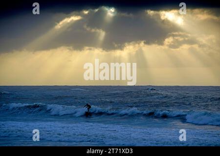 Swansea, Royaume-Uni. 13 novembre 2023. Un surfeur solitaire profitant des vagues à Langland Bay près de Swansea sous un ciel spectaculaire alors que Storm Debi se déplace dans le sud du Royaume-Uni ce matin. Crédit : Phil Rees/Alamy Live News Banque D'Images