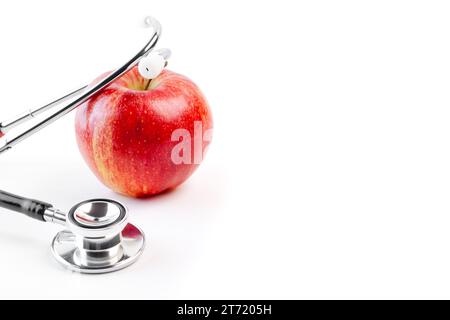 détail du stéthoscope médical sur pomme rouge sur fond blanc avec espace pour le texte Banque D'Images