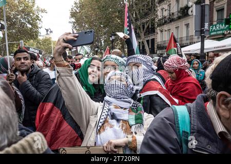 Madrid, Espagne. 11 novembre 2023. Les manifestants prennent des selfies pendant la manifestation. Une manifestation massive menée par le Coordonnateur d’Etat des associations solidaires avec le Sahara (CEAS-Sahara) visite Madrid pour réclamer l’autodétermination du Sahara. Crédit : SOPA Images Limited/Alamy Live News Banque D'Images