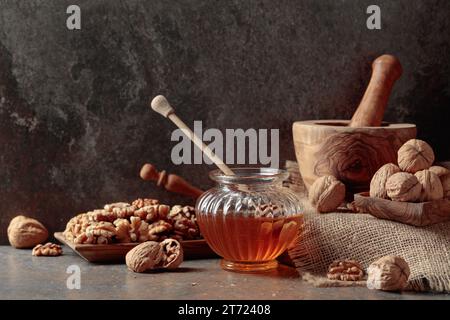 Miel et noix sur une table de cuisine ancienne. Banque D'Images