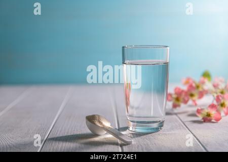 poudre de collagène matcha dans une cuillère et un verre d'eau, concept sain et anti-âge. Créatif Banque D'Images