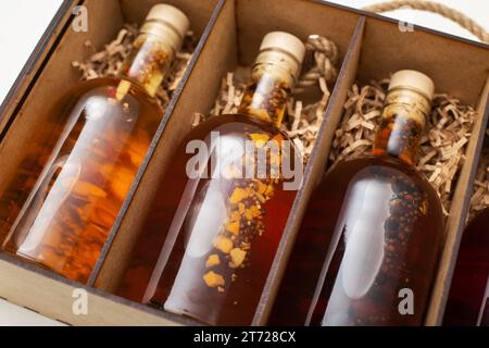 Bouteilles avec brandy de boisson alcoolisée maison chère et cognac dans une boîte en bois, gros plan. Banque D'Images