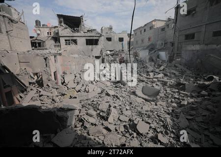 Des Palestiniens inspectent la maison détruite de la famille Ghanem, suite à une frappe aérienne israélienne sur le camp de réfugiés de Bureij les Palestiniens inspectent la maison détruite de la famille Ghanem, suite à une frappe aérienne israélienne sur le camp de réfugiés de Bureij, au centre de la bande de Gaza, le 13 novembre 2023. Israël est confronté à une pression internationale intense pour minimiser les souffrances des civils dans le cadre d’une opération aérienne et terrestre massive qui, selon les autorités du Hamas, a déjà tué plus de 11 000 personnes, dont des milliers d’enfants. La campagne militaire a eu lieu après que les combattants du Hamas ont franchi la frontière militarisée avec Israël en octobre Banque D'Images