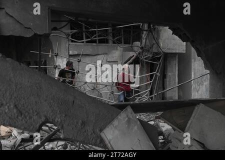 Des Palestiniens inspectent la maison détruite de la famille Ghanem, suite à une frappe aérienne israélienne sur le camp de réfugiés de Bureij les Palestiniens inspectent la maison détruite de la famille Ghanem, suite à une frappe aérienne israélienne sur le camp de réfugiés de Bureij, au centre de la bande de Gaza, le 13 novembre 2023. Israël est confronté à une pression internationale intense pour minimiser les souffrances des civils dans le cadre d’une opération aérienne et terrestre massive qui, selon les autorités du Hamas, a déjà tué plus de 11 000 personnes, dont des milliers d’enfants. La campagne militaire a eu lieu après que les combattants du Hamas ont franchi la frontière militarisée avec Israël en octobre Banque D'Images