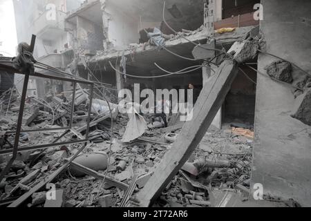 Camp de réfugiés de Bureij, Palestine. 13 novembre 2023. Des Palestiniens inspectent la maison détruite de la famille Ghanem, suite à une frappe aérienne israélienne sur le camp de réfugiés de Bureij les Palestiniens inspectent la maison détruite de la famille Ghanem, suite à une frappe aérienne israélienne sur le camp de réfugiés de Bureij, au centre de la bande de Gaza, le 13 novembre 2023. Israël est confronté à une pression internationale intense pour minimiser les souffrances des civils dans le cadre d’une opération aérienne et terrestre massive qui, selon les autorités du Hamas, a déjà tué plus de 11 000 personnes, dont des milliers d’enfants. Crédit : Imago/Alamy Live News Banque D'Images