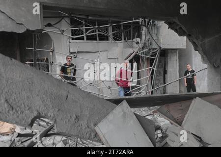 Camp de réfugiés de Bureij, Palestine. 13 novembre 2023. Des Palestiniens inspectent la maison détruite de la famille Ghanem, suite à une frappe aérienne israélienne sur le camp de réfugiés de Bureij les Palestiniens inspectent la maison détruite de la famille Ghanem, suite à une frappe aérienne israélienne sur le camp de réfugiés de Bureij, au centre de la bande de Gaza, le 13 novembre 2023. Israël est confronté à une pression internationale intense pour minimiser les souffrances des civils dans le cadre d’une opération aérienne et terrestre massive qui, selon les autorités du Hamas, a déjà tué plus de 11 000 personnes, dont des milliers d’enfants. Crédit : Imago/Alamy Live News Banque D'Images