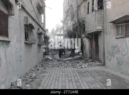 Camp de réfugiés de Bureij, Palestine. 13 novembre 2023. Des Palestiniens inspectent la maison détruite de la famille Ghanem, suite à une frappe aérienne israélienne sur le camp de réfugiés de Bureij les Palestiniens inspectent la maison détruite de la famille Ghanem, suite à une frappe aérienne israélienne sur le camp de réfugiés de Bureij, au centre de la bande de Gaza, le 13 novembre 2023. Israël est confronté à une pression internationale intense pour minimiser les souffrances des civils dans le cadre d’une opération aérienne et terrestre massive qui, selon les autorités du Hamas, a déjà tué plus de 11 000 personnes, dont des milliers d’enfants. Crédit : Imago/Alamy Live News Banque D'Images