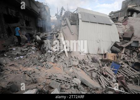 Camp de réfugiés de Bureij, Palestine. 13 novembre 2023. Des Palestiniens inspectent la maison détruite de la famille Ghanem, à la suite d'une frappe aérienne israélienne sur le camp de réfugiés de Bureij les Palestiniens inspectent la maison détruite de la famille Ghanem, à la suite d'une frappe aérienne israélienne sur le camp de réfugiés de Bureij, au centre de la bande de Gaza. Crédit : Imago/Alamy Live News Banque D'Images