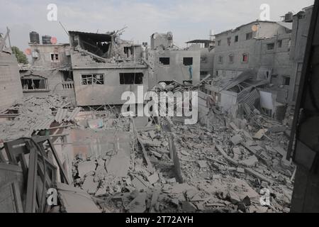 Camp de réfugiés de Bureij, Palestine. 13 novembre 2023. Des Palestiniens inspectent la maison détruite de la famille Ghanem, suite à une frappe aérienne israélienne sur le camp de réfugiés de Bureij les Palestiniens inspectent la maison détruite de la famille Ghanem, suite à une frappe aérienne israélienne sur le camp de réfugiés de Bureij, au centre de la bande de Gaza, le 13 novembre 2023. Israël est confronté à une pression internationale intense pour minimiser les souffrances des civils dans le cadre d’une opération aérienne et terrestre massive qui, selon les autorités du Hamas, a déjà tué plus de 11 000 personnes, dont des milliers d’enfants. Crédit : Imago/Alamy Live News Banque D'Images