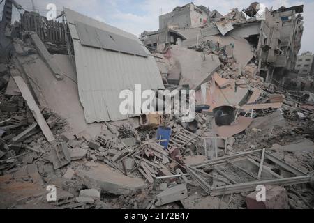 Camp de réfugiés de Bureij, Palestine. 13 novembre 2023. Des Palestiniens inspectent la maison détruite de la famille Ghanem, suite à une frappe aérienne israélienne sur le camp de réfugiés de Bureij les Palestiniens inspectent la maison détruite de la famille Ghanem, suite à une frappe aérienne israélienne sur le camp de réfugiés de Bureij, au centre de la bande de Gaza, le 13 novembre 2023. Israël est confronté à une pression internationale intense pour minimiser les souffrances des civils dans le cadre d’une opération aérienne et terrestre massive qui, selon les autorités du Hamas, a déjà tué plus de 11 000 personnes, dont des milliers d’enfants. Crédit : Imago/Alamy Live News Banque D'Images