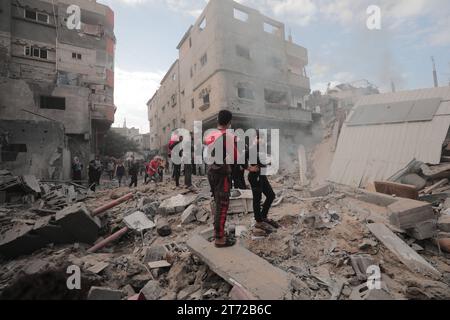 Camp de réfugiés de Bureij, Palestine. 13 novembre 2023. Des Palestiniens inspectent la maison détruite de la famille Ghanem, suite à une frappe aérienne israélienne sur le camp de réfugiés de Bureij les Palestiniens inspectent la maison détruite de la famille Ghanem, suite à une frappe aérienne israélienne sur le camp de réfugiés de Bureij, au centre de la bande de Gaza, le 13 novembre 2023. Israël est confronté à une pression internationale intense pour minimiser les souffrances des civils dans le cadre d’une opération aérienne et terrestre massive qui, selon les autorités du Hamas, a déjà tué plus de 11 000 personnes, dont des milliers d’enfants. Crédit : Imago/Alamy Live News Banque D'Images