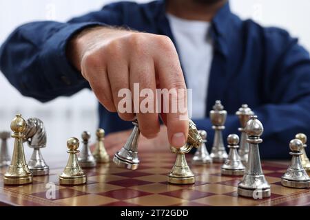 Homme déplaçant chevalier sur l'échiquier, vue rapprochée Banque D'Images