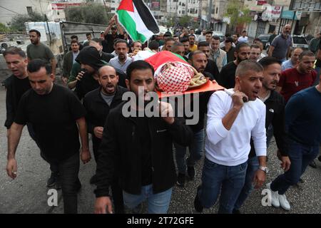 Les personnes en deuil portent le corps d'Issa al-Qadi, un palestinien de 66 ans qui a été abattu. Les personnes en deuil portent le corps d'Issa al-Qadi, un palestinien de 66 ans qui a été abattu alors qu'il conduisait son taxi lors d'une opération militaire menée par les forces israéliennes plus tôt dans la journée, avant son enterrement lors des funérailles à Hébron en Cisjordanie occupée le 13 novembre 2023. Photo de Mamoun Wazwaz apaimages Hébron Cisjordanie territoire palestinien 131223 Hebron MW 007 Copyright : xapaimagesxMamounxWazwazxxapaimagesx crédit : Imago/Alamy Live News Banque D'Images