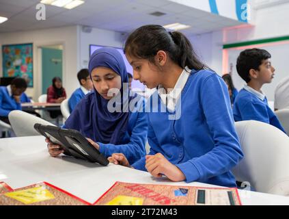 Élèves asiatiques utilisant une tablette en classe dans une école britannique. Banque D'Images