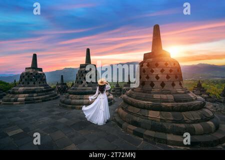 Visite touristique dans l'ancien plus grand temple bouddhiste Borobudur au lever du soleil à Java, Indonésie. Banque D'Images