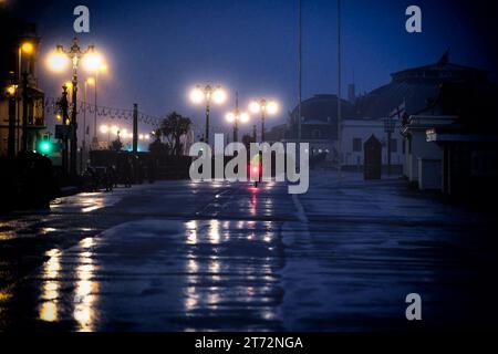 Un cycliste portant des vêtements de haute visibilité chevauchant le long de la promenade sous la pluie sur un Worthing Beach matin de novembre, Worthing, Royaume-Uni le 13 novembre 2023. Photo de Julie Edwards. Banque D'Images