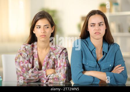 Portrait en vue de face de deux amis en colère s'ignorant à la maison Banque D'Images