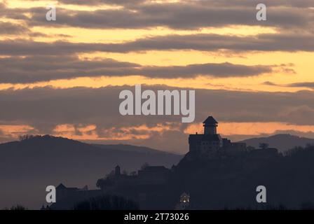 Silhouette de château au lever du soleil dans le brouillard du matin. Debout sur un rocher. Avec un beau ciel nuageux coloré. Paysage d'automne. Trencin, Slovaquie Banque D'Images