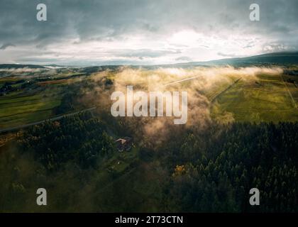 Une vue aérienne d'une vallée paisible avec un brouillard roulant sur des arbres verdoyants. Saint-Donat, Québec Banque D'Images
