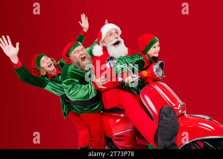 Photo de profil de l'équipe fou quatre personnes mobylette ont partie amusement porter santa elf costume isolé couleur gris fond Banque D'Images